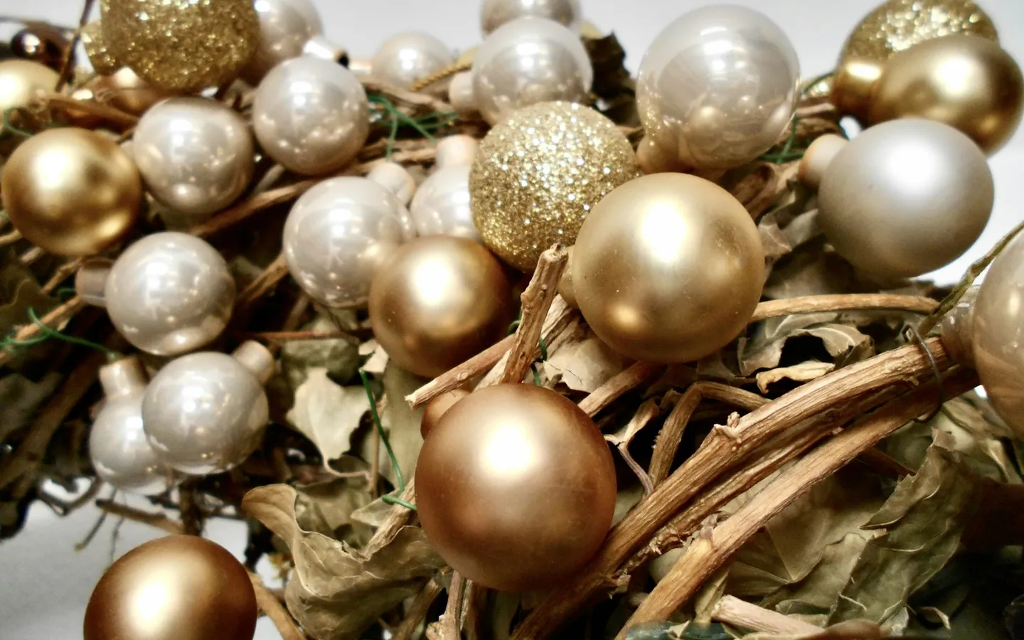 Pile of gold and silver Christmas baubles on a bed of twigs