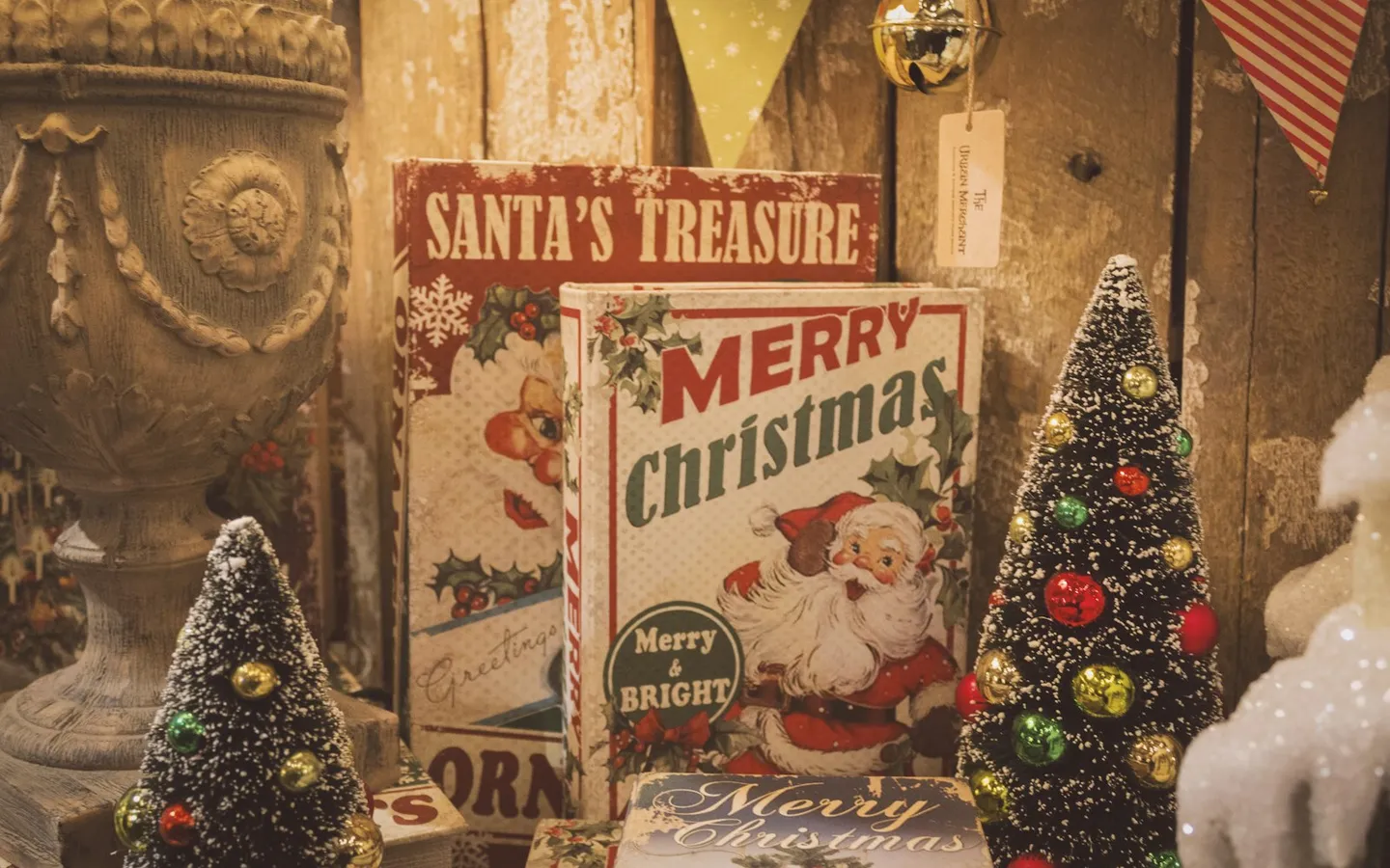 Vintage Christmas signs reading Santa's Treasure and Merry Christmas between small bottle-brush trees